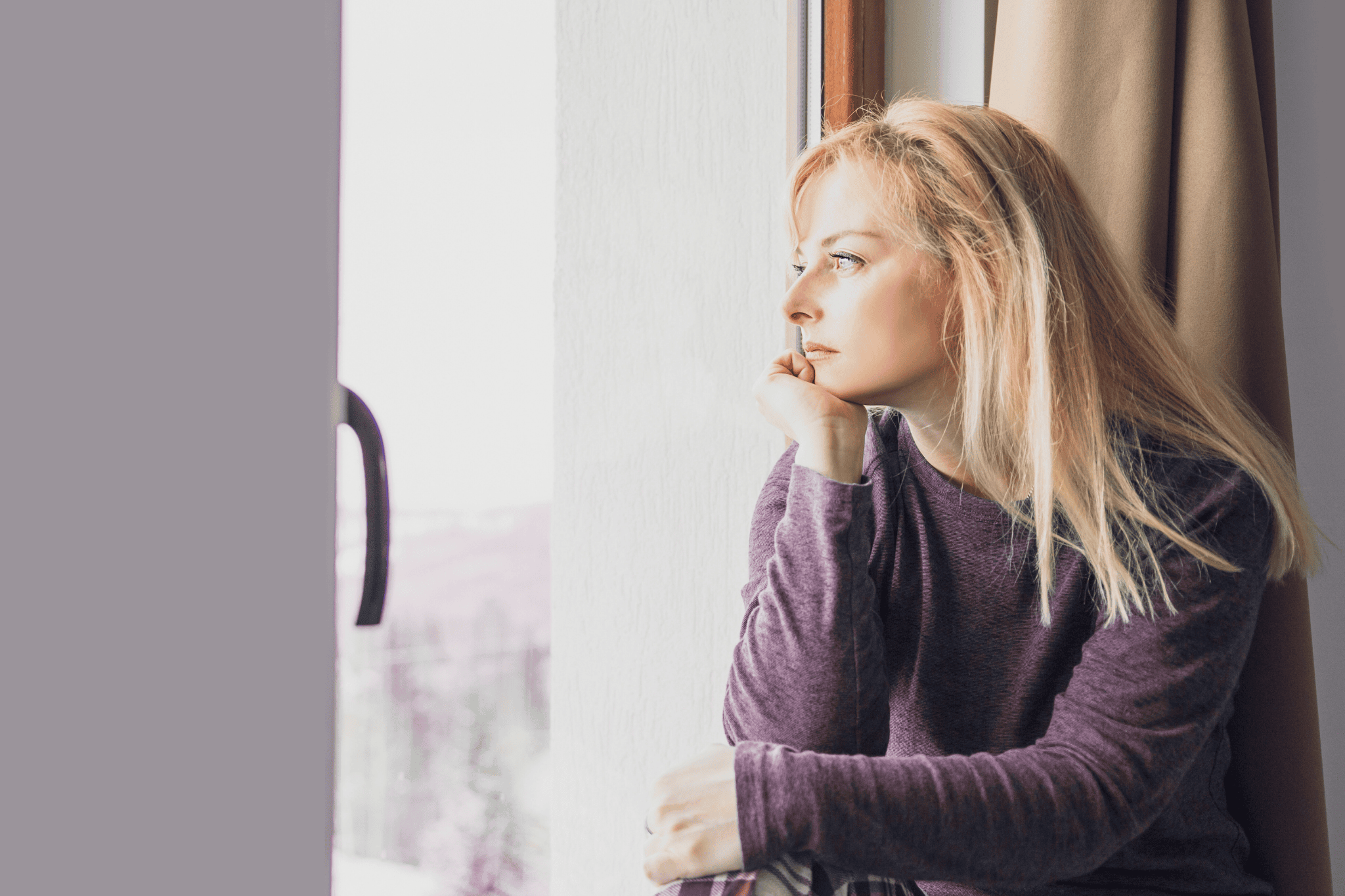 Einsame Mutter schaut nachdenklich aus dem Fenster